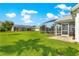 Spacious backyard features a screened-in patio with a hot tub, and green grass at 804 Santa Rita Way, Lady Lake, FL 32159
