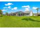 Expansive backyard featuring lush green grass, a screened lanai, and picturesque landscaping at 804 Santa Rita Way, Lady Lake, FL 32159