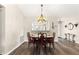 Cozy dining room features wood floors, stylish chandelier, and a pass-through to the kitchen at 804 Santa Rita Way, Lady Lake, FL 32159