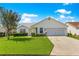 Beautiful single-story home featuring a two-car garage, lush landscaping, and a well-maintained lawn on a sunny day at 804 Santa Rita Way, Lady Lake, FL 32159