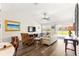 Cozy living room with hardwood floors, vaulted ceilings, TV, fan, and sliding glass doors to the pool at 804 Santa Rita Way, Lady Lake, FL 32159