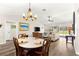 Open-concept living space featuring a dining table, hardwood floors, vaulted ceilings, and a comfortable seating area at 804 Santa Rita Way, Lady Lake, FL 32159