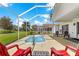 Screened-in patio features a hot tub, seating, and views of the lush backyard at 804 Santa Rita Way, Lady Lake, FL 32159