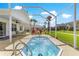 Screened in patio with a hot tub with seating and view of the well manicured lawn at 804 Santa Rita Way, Lady Lake, FL 32159