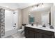 Bathroom with double vanity, a shower tub, and decorative mirror at 872 Griffon Ave, Lake Alfred, FL 33850