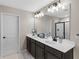 Elegant bathroom featuring double sinks, modern lighting, and a glass-enclosed shower at 872 Griffon Ave, Lake Alfred, FL 33850