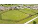Aerial view of the community dog park, featuring grassy areas, benches, and a fenced perimeter at 872 Griffon Ave, Lake Alfred, FL 33850