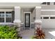 View of the home's front porch with decorative stone pillars and colorful landscaping at 872 Griffon Ave, Lake Alfred, FL 33850