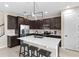 Modern kitchen features stainless steel appliances, a large island with bar seating, and stylish dark cabinets at 872 Griffon Ave, Lake Alfred, FL 33850