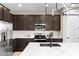 Stylish kitchen showcases stainless steel appliances, dark cabinets, and white countertops at 872 Griffon Ave, Lake Alfred, FL 33850
