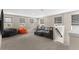 A loft area with neutral walls, carpet, a gray couch, and two bean bag chairs creates a cozy living space at 872 Griffon Ave, Lake Alfred, FL 33850