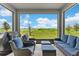 Screened patio offers serene outdoor living space with wicker furniture and views of the lake and landscaping at 872 Griffon Ave, Lake Alfred, FL 33850