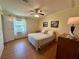 Cozy bedroom with light walls and wood-look floors and a large window at 902 Rose Ln, Lady Lake, FL 32159