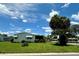 Charming home exterior with lush green lawn, mature palm trees, and bright sky at 902 Rose Ln, Lady Lake, FL 32159