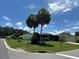 Neighborhood street view showcasing well-maintained lawns and mature palm trees under a bright blue sky at 902 Rose Ln, Lady Lake, FL 32159