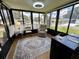 Comfortable sunroom boasts natural light and a cozy seating area with large windows at 902 Rose Ln, Lady Lake, FL 32159