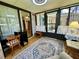 Bright sunroom features large windows, neutral decor, and a patterned area rug at 902 Rose Ln, Lady Lake, FL 32159