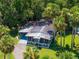 Attractive home featuring a screened-in porch, carport, well-manicured lawn, and lush tropical landscaping at 10 Cocos Plumosa Dr, Eustis, FL 32726