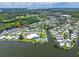 Beautiful aerial view of the community with a pond, community pool, and recreation center in a lush, green setting at 10 Cocos Plumosa Dr, Eustis, FL 32726