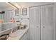 Updated bathroom vanity with large mirror, ample storage, and coastal-themed decorations at 10 Cocos Plumosa Dr, Eustis, FL 32726