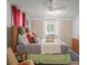 Bedroom with a king bed, dresser, closet, and comfy chair; illuminated by a ceiling fan and natural light at 10 Cocos Plumosa Dr, Eustis, FL 32726