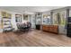 Bright dining area featuring wood-look flooring, charming chandelier, and multiple windows at 10 Cocos Plumosa Dr, Eustis, FL 32726