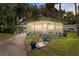 Single-story home with screen porch, carport, and decorative landscaping creating a welcoming curb appeal at 10 Cocos Plumosa Dr, Eustis, FL 32726