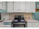 Charming kitchen featuring white cabinetry, stainless steel appliances, and a tiled backsplash at 10 Cocos Plumosa Dr, Eustis, FL 32726