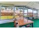 Bright lanai with a view of tropical palm trees and a spacious table and chairs at 10 Cocos Plumosa Dr, Eustis, FL 32726