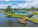 Scenic view of a waterfront community center featuring a pool, dock, and picturesque waterfront surroundings at 10 Cocos Plumosa Dr, Eustis, FL 32726