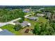 Aerial view of a home with a sunroom, surrounded by lush greenery, and adjacent to a quiet street at 10331 Sw 45Th Ave, Ocala, FL 34476