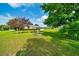Large backyard with trees, a sunroom, and utility connections visible on the lawn at 10331 Sw 45Th Ave, Ocala, FL 34476