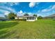 Manicured backyard featuring a lush lawn and an inviting enclosed sunroom attached to the house at 10331 Sw 45Th Ave, Ocala, FL 34476
