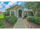 Inviting home featuring a well-manicured lawn, mature shrubbery, and an arched entryway at 10331 Sw 45Th Ave, Ocala, FL 34476