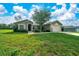Charming single-story home with a well-manicured lawn and mature tree in the front yard at 10331 Sw 45Th Ave, Ocala, FL 34476