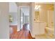 Hallway view showcasing hardwood floors leading to a bathroom with bright white features at 10331 Sw 45Th Ave, Ocala, FL 34476