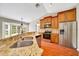 Beautiful kitchen featuring granite countertops, stainless steel appliances, wood cabinets, and wood flooring at 10331 Sw 45Th Ave, Ocala, FL 34476
