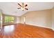 Inviting living room with hardwood floors, a ceiling fan, and a large window at 10331 Sw 45Th Ave, Ocala, FL 34476