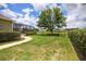 Spacious backyard featuring lush lawn, mature trees, a serene pond, and screened lanai, ideal for relaxation at 1043 Juliette Blvd, Mount Dora, FL 32757