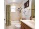 This bathroom includes a vanity, a bathtub with a shower, decorated with tile and bronze hardware at 1043 Juliette Blvd, Mount Dora, FL 32757