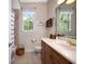 Bright bathroom featuring a vanity with marble counters, and a shower-tub with blue accents and natural light at 1043 Juliette Blvd, Mount Dora, FL 32757