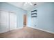 This carpeted light blue bedroom contains ample closet space and accent shelves for storage and display at 1043 Juliette Blvd, Mount Dora, FL 32757