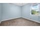 Serene light blue bedroom offering carpet and a window with sheer white curtains, creating a peaceful retreat at 1043 Juliette Blvd, Mount Dora, FL 32757