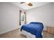 Bright bedroom with neutral walls, plush carpet, and a comfortable blue bed, complemented by natural light at 1043 Juliette Blvd, Mount Dora, FL 32757