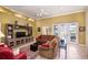 Comfortable living room featuring a ceiling fan, media center, and sliding doors to the outside at 1043 Juliette Blvd, Mount Dora, FL 32757