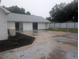 Home exterior showcasing a spacious concrete patio, white siding, and a modern metal fence, perfect for outdoor living at 11532 Beaman Cir, Clermont, FL 34711