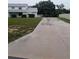 Long concrete driveway leading to a home with large yard and covered parking at 11532 Beaman Cir, Clermont, FL 34711