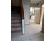 Tiled hallway with staircase, leading to kitchen and other rooms at 11532 Beaman Cir, Clermont, FL 34711