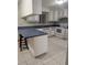 Kitchen featuring white appliances, breakfast bar, and blue countertops at 11532 Beaman Cir, Clermont, FL 34711