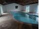 Indoor pool featuring clear blue water, open ceiling rafters, and ample natural light at 11532 Beaman Cir, Clermont, FL 34711